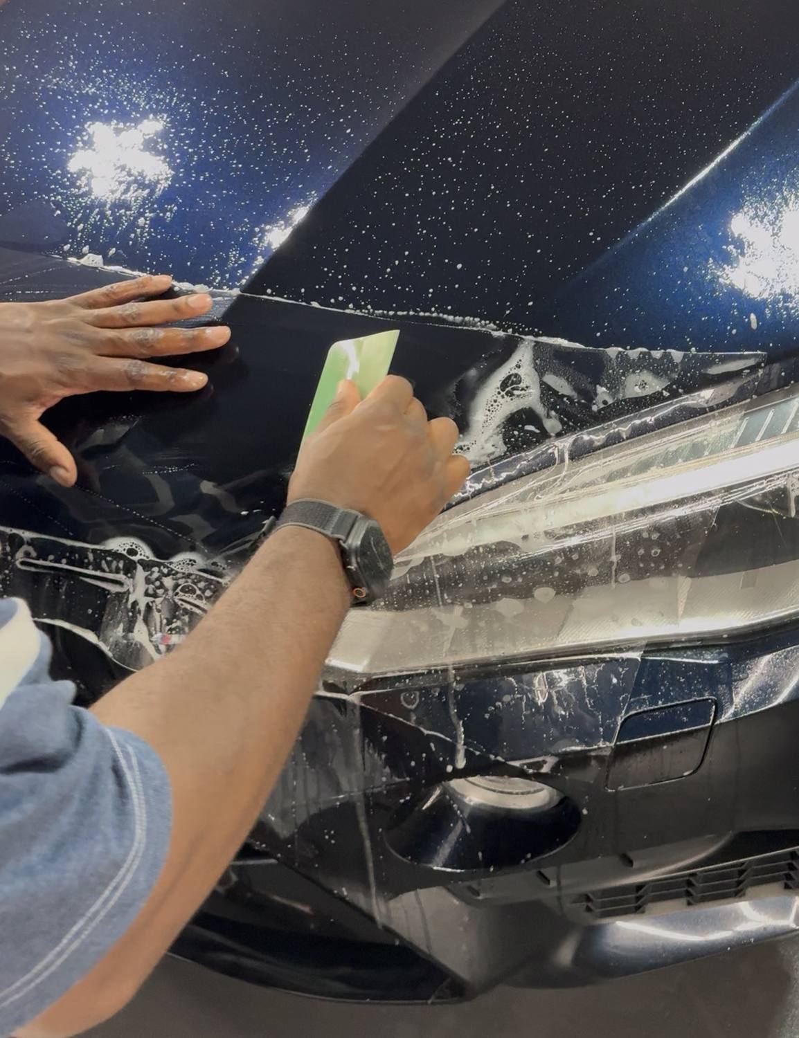 Tariq installing paint protection film on a BMW X5M