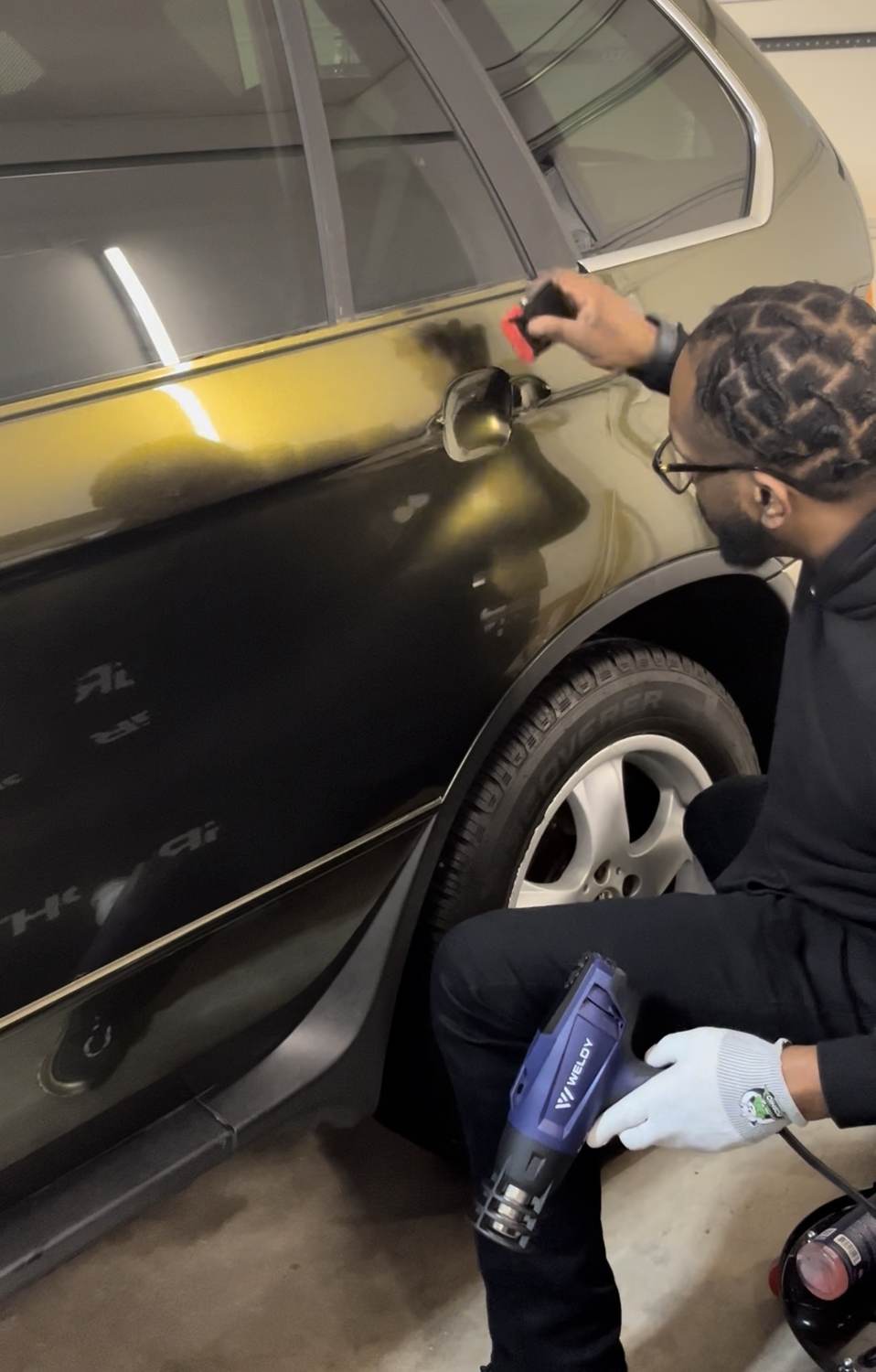 Tariq installing film on a vehicle in the shop